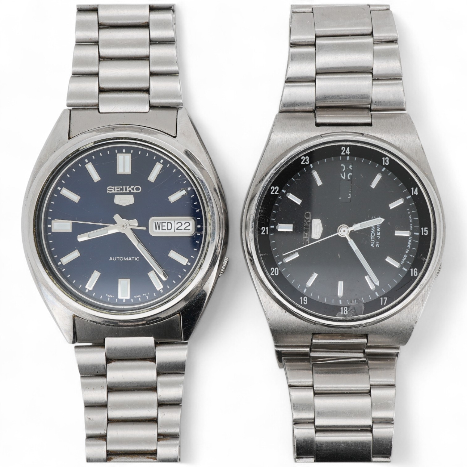 Two gentleman's recent stainless steel Seiko 5 automatic day/date wrist watches, one with black dial, the other blue dial, case diameters 36mm, both on stainless steel Seiko straps (one a.f.). no boxes or paperwork.